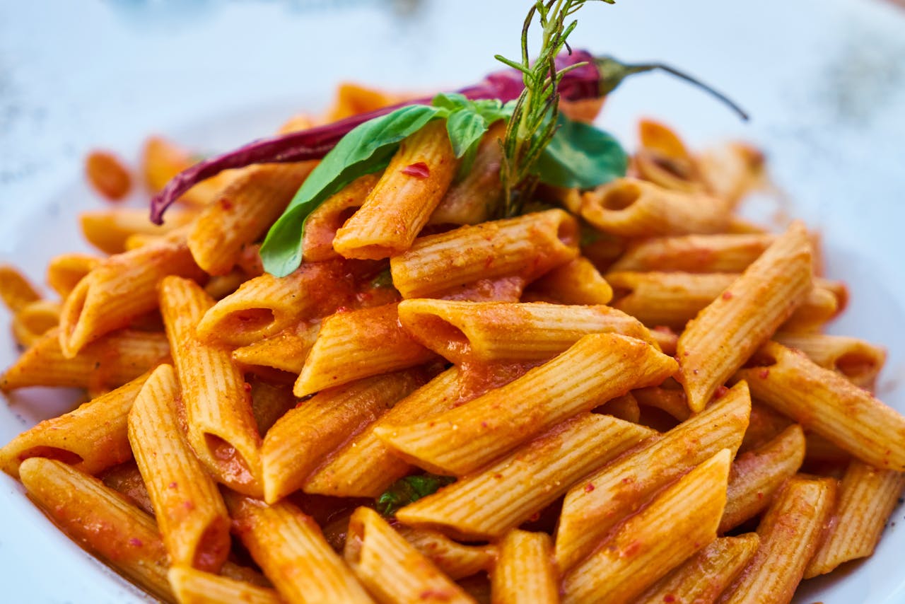 services-03 Savor the flavors of Italian cuisine with this close-up photo of tasty penne pasta in tomato sauce.