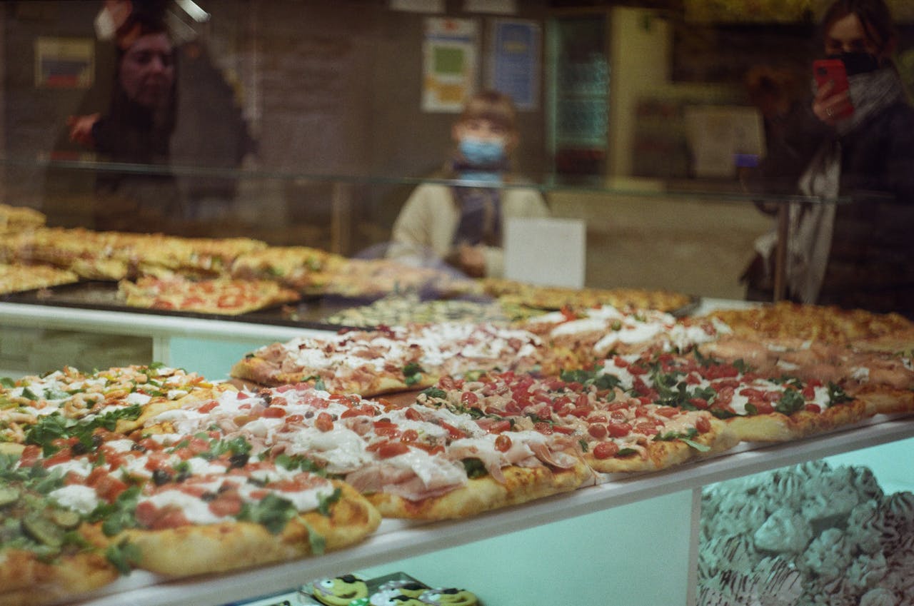 why-choose-us Tempting display of assorted pizzas in a Bergamo bakery showcasing Italian culinary delights.
